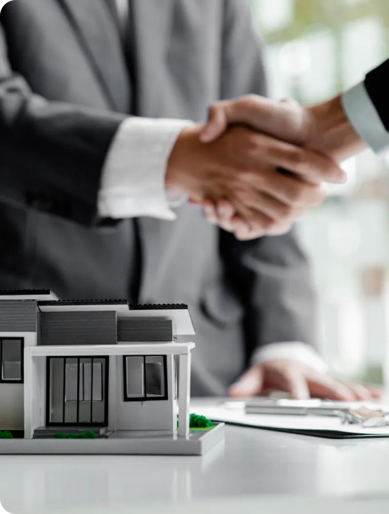A handshake over a model house